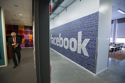 Karl Petersen, Lulea's mayor, walks past a logo at Facebook Inc.'s new data storage center near the Arctic Circle in Lulea, Sweden, on Wednesday, June 12, 2013. The data center is Facebook's first outside the U.S., poised to handle all data processing from Europe, Middle East and Africa and the server hub is largest of its kind in Europe, and most northerly of its magnitude anywhere on earth. Photographer: Simon Dawson/Bloomberg ***  Local Caption *** Karl Petersen
