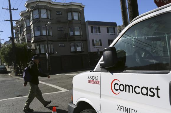 A Comcast sign is shown on the side of a vehicle in San Francisco