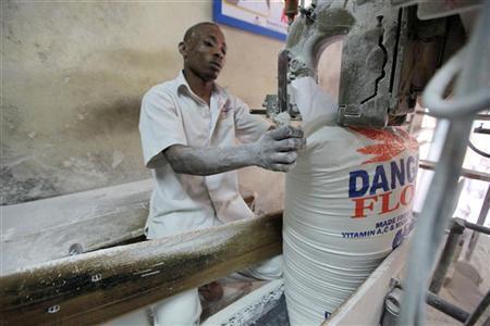 A worker operates a bag-sealing machine at the Dangote flour mill in Apapa district in Nigeria's commercial capital of Lagos
