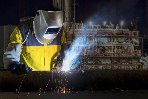 Worker with protective mask welding metal