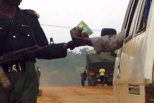 A-Nigerian-police-officer-collects-N20-from-a-driver-600×400