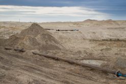 Steal big pipeline on a sand. Old pipes joint in a desert
