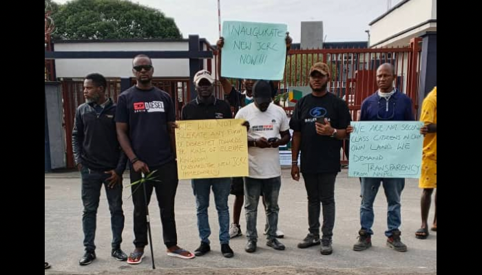Placard-carrying community people at the gates
